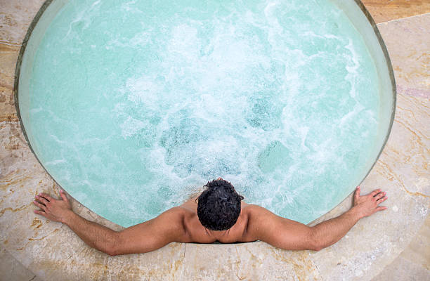 Man relaxing in a hot tub Handsome man relaxing at the spa in a hot tub hot tub stock pictures, royalty-free photos & images