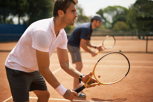 Sport, fitness and tennis player team discussion of game strategy while walking together on a tennis court from above. Professional, athletic and competitive man and woman planning and training