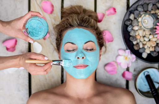 Beautiful woman at the spa wearing a facemask - beauty concepts
