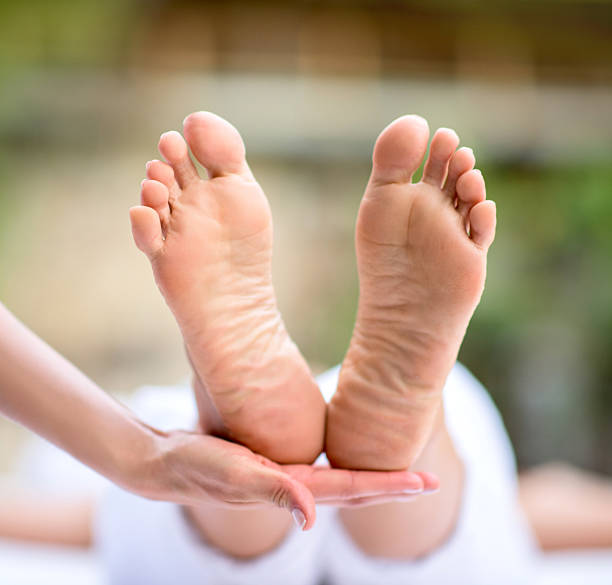 woman at the spa getting a pedicure - reflexology pedicure massaging human foot imagens e fotografias de stock