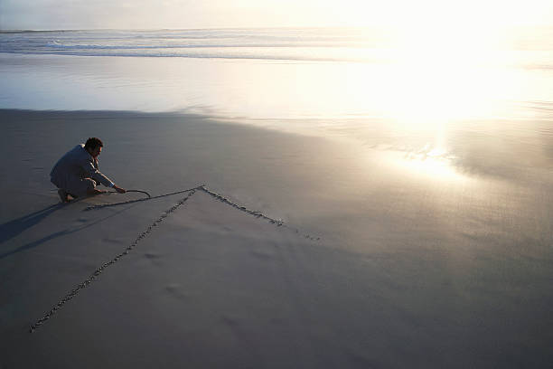 istock Businessman Drawing Arrow In Sand 497180451