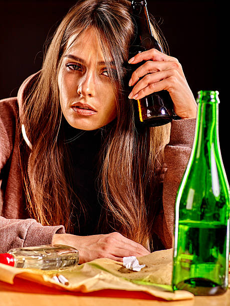 istock Drunk girl holding bottle of vodka 497180634