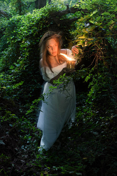 istock Woman with flame to light path in woods 497181412