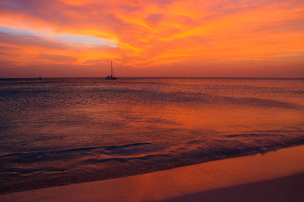 spectaculaire coucher de soleil en bateau à palm beach, aruba, la mer des caraïbes - sailing sailboat sunset aruba photos et images de collection