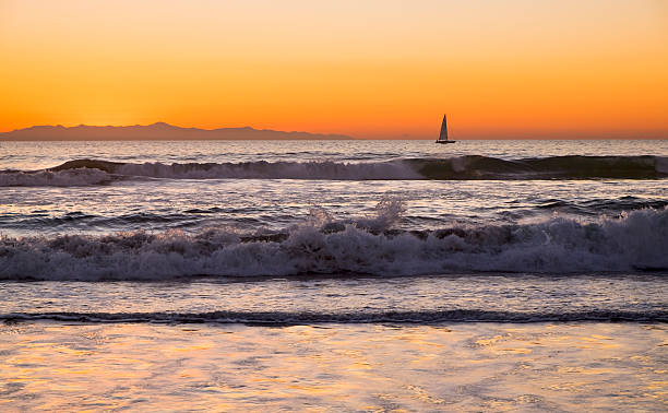 sailing at sunset A small boat sails north up the southern California coast at sundown. anacapa island stock pictures, royalty-free photos & images