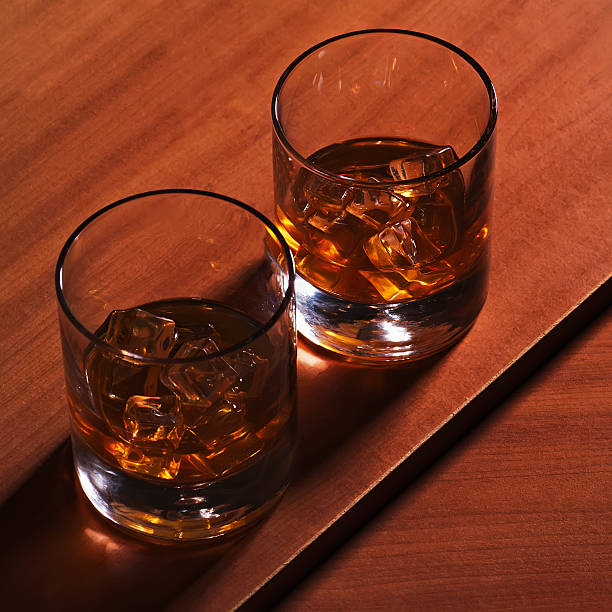 istock Highball whiskey glass with ice on wooden background. 497185567