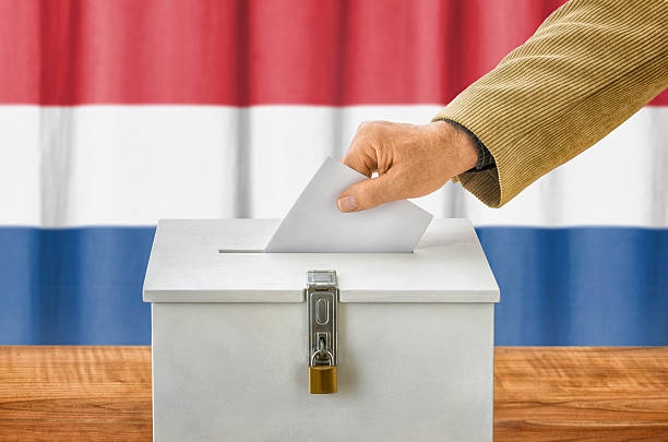 istock Man putting a ballot into a voting box - Netherlands 497189398