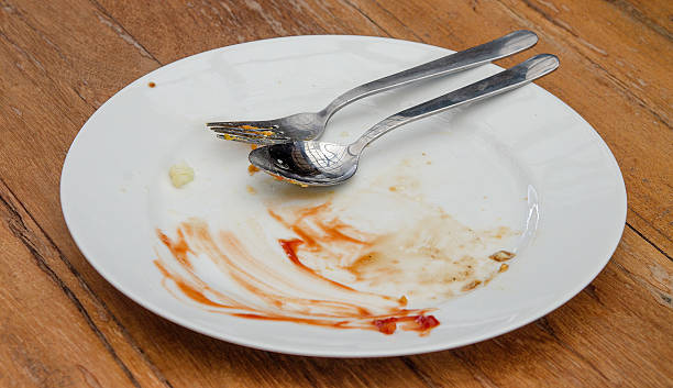 istock Dirty plate with spoon and fork on wood table 497197793
