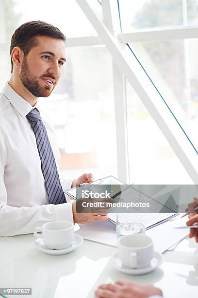 Discussing A Document Stock Photo - Download Image Now - Financial Report, 20-29 Years, Adult