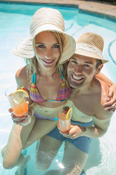 istock Happy young couple in the pool with drinks 497198461