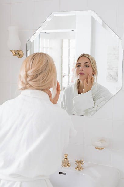istock Beautiful woman looking at herself in the bathroom mirror 497198529