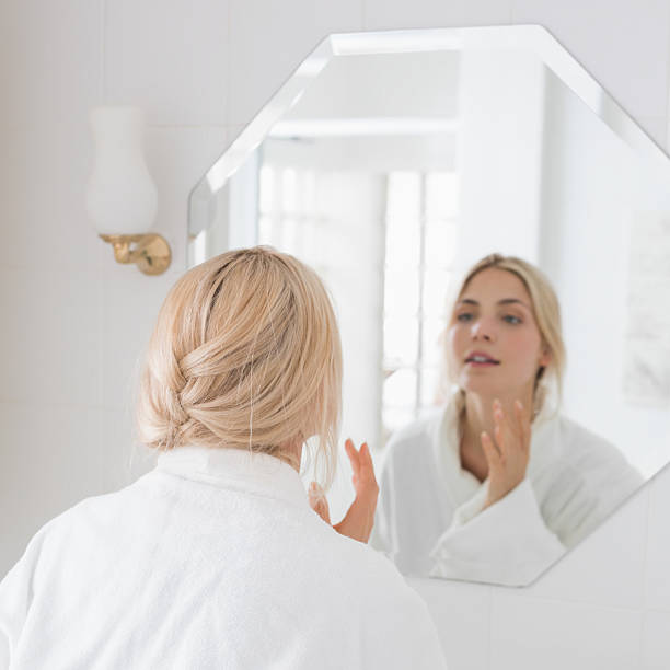 istock Beautiful woman looking at herself in the bathroom mirror 497200933