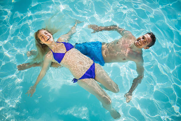 istock Happy young couple in swimming pool 497200991