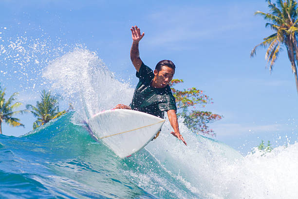 surfer sur la vague.  l'île de bali.  en indonésie. - spraying beaches summer sunlight photos et images de collection