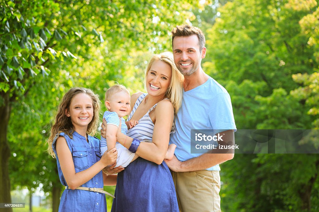 Happy family in a park Outdoor portrait of happy parents with their children.  6-11 Months Stock Photo