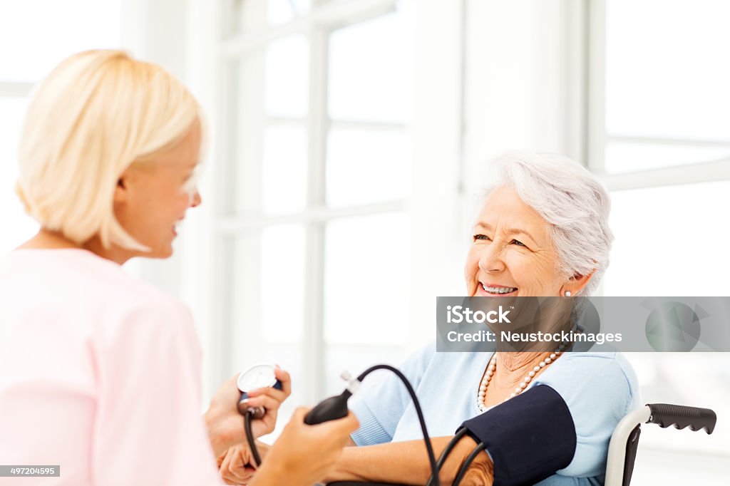 Старший Женский артериальное давление рассматривается, медсестра - Стоковые фото Тонометр роялти-фри