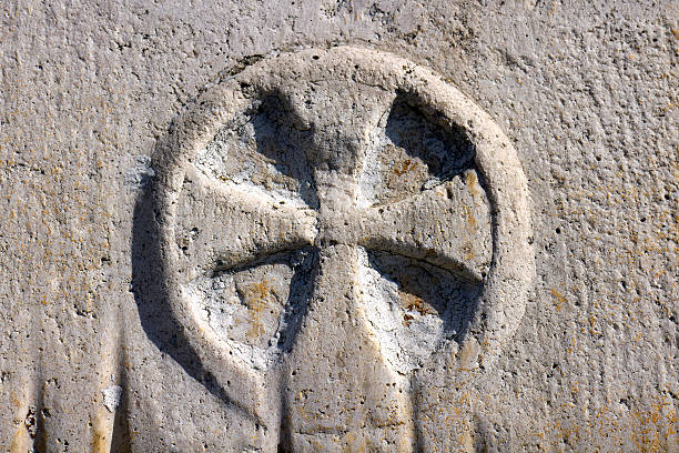 Sun cross or solar wheel Cross in the circle on stone doorpost of Church of St Margaret in Nerezisca on Brac island, Croatia old catholic church on island brac croatia stock pictures, royalty-free photos & images