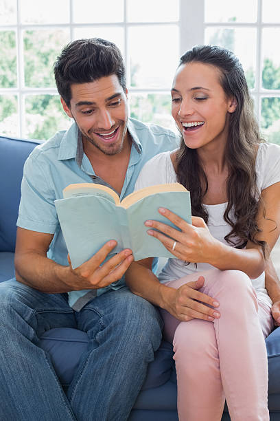 istock Attractive couple enjoy reading book on the couch 497209543