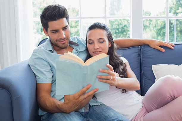 istock Attractive couple enjoy story book on sofa 497209555