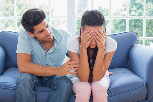 istock Boyfriend comforts crying girlfriend on the couch 497209557