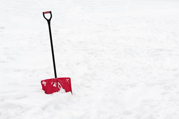 istock Red snow shovel standing in snow. 497210174