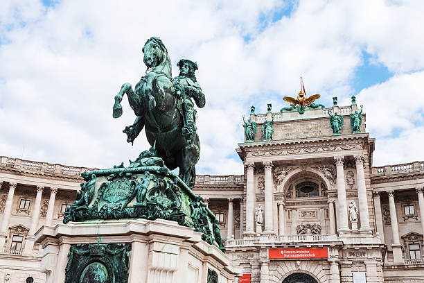 statue of Prince Eugene of Savoy in Vienna Vienna, Austria — September 27, 2015: statue of Prince Eugene of Savoy on Heldenplatz and facade of Neue Burg in Hofburg Palace, Vienna, Austria. New Castle wing today houses a number of museums and reading rooms of Austrian National Library heldenplatz stock pictures, royalty-free photos & images