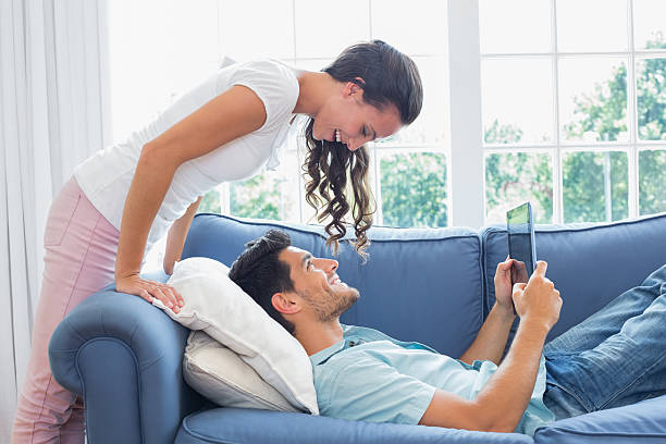 istock Attractive girlfriend leaning over her boyfriend smiling at each 497211757