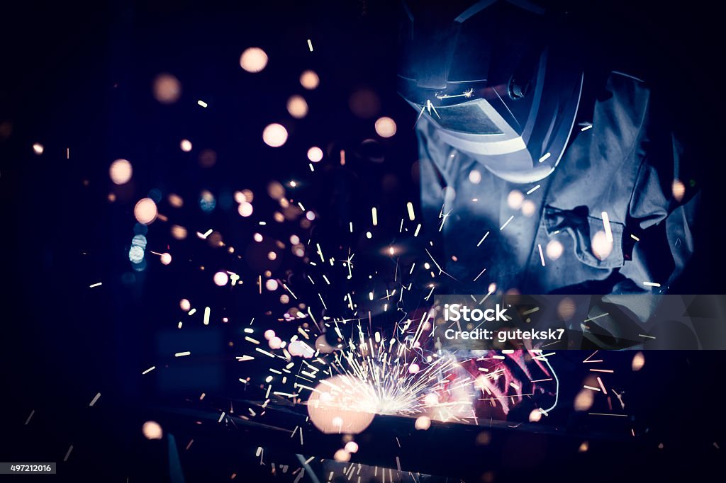 Employee welding steel Employee welding steel with sparks, using MiG MAG welder Welder Stock Photo