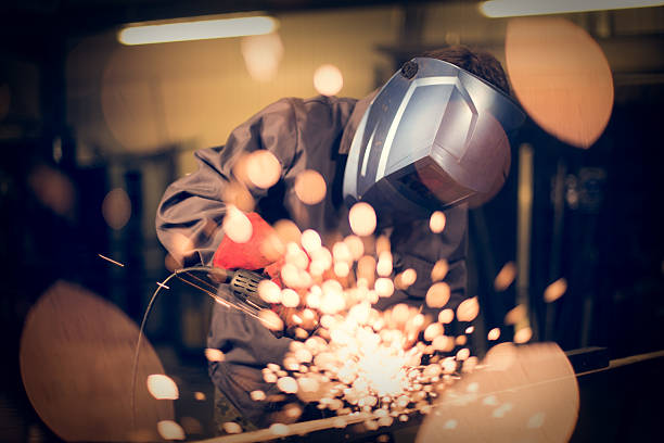istock Employee grinding steel with sparks 497212104