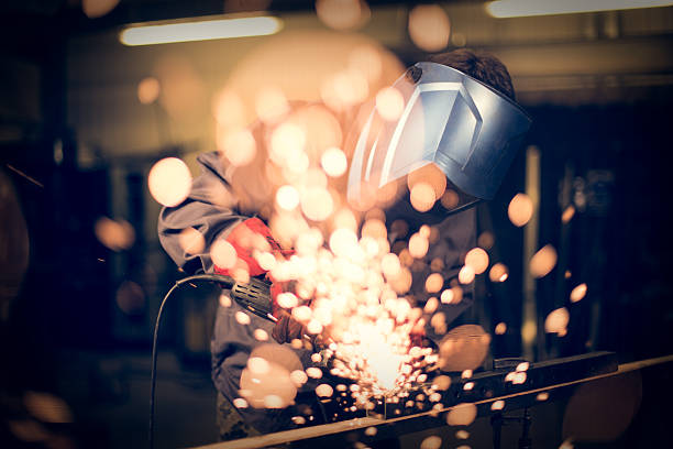 istock Employee grinding steel with sparks 497212204