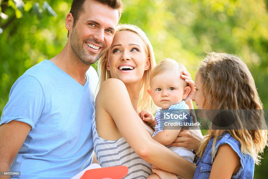 Happy family Outdoor portrait of happy parents with their two children.  6-11 Months Stock Photo