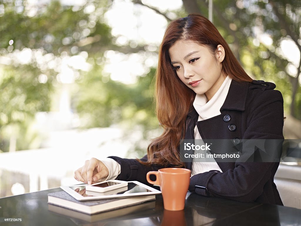 young woman thinking in coffee shop young asian adult woman sitting by the window thinking in coffee shop. 20-29 Years Stock Photo
