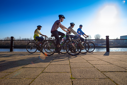 A group of four friends ride their bikes along the quayside.