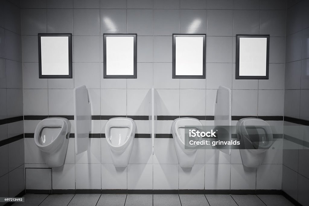Empty advertisement frames in public toilet Empty advertisement frames in public toilet for men Urinal Stock Photo