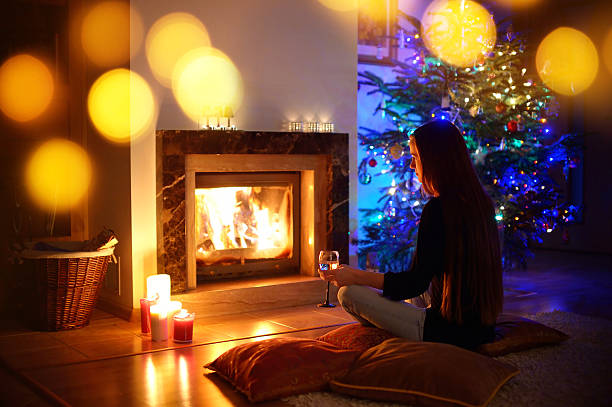 istock Woman having a drink by a fireplace on Christmas 497214952