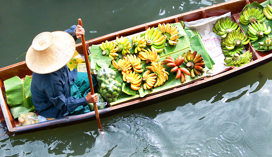 Cai Rang, Can Tho, Vietnam - November 05, 2022: The floating market in the Mekong Delta at Cai Rang in Vietnam. Woman on boat selling pumpkins.