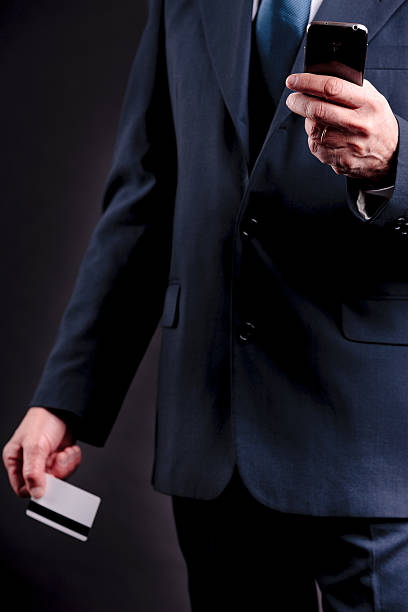 istock old businessman with credit card and mobile 497216423