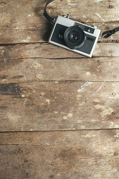 istock Vintage film camera on wooden table. 497216634