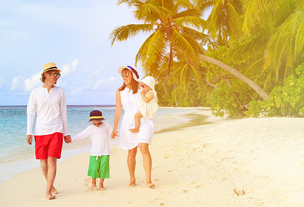 istock family with two kids walking at tropical beach 497217594