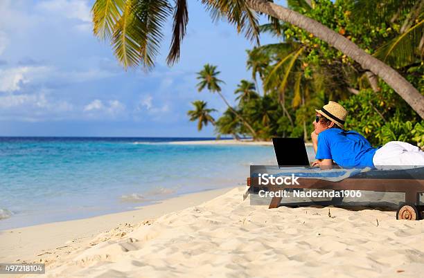 Young Man With Laptop On Tropical Beach Stock Photo - Download Image Now - 2015, Bay of Water, Beach