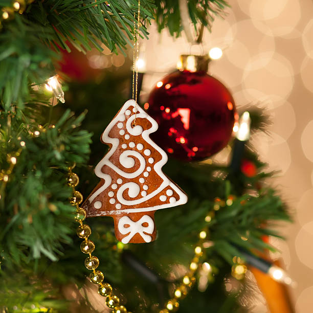 Christmas gingerbread decoration on a christmas tree. Background of de-focused lights. Christmas decoration on christmas tree.
