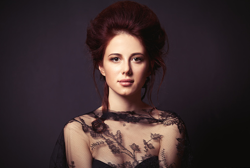 Portrait of a beautiful woman in style dress on dark backgorund