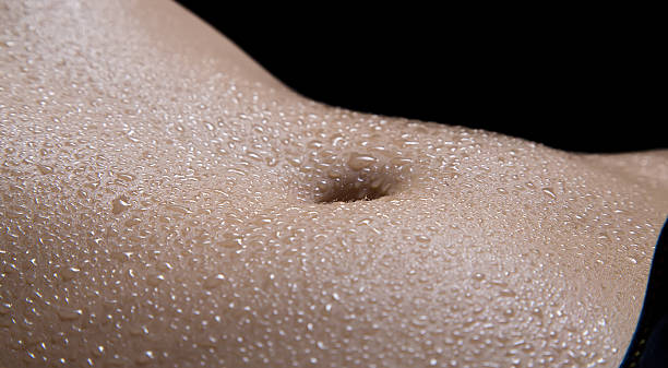 istock Woman's belly with drops in the dark 497222984