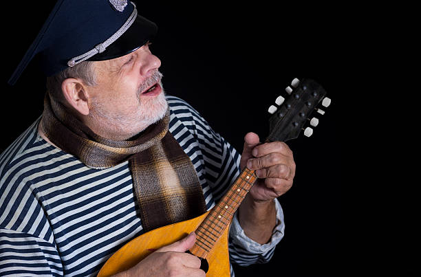 istock man in striped vest and comforter with mandolin 497225550