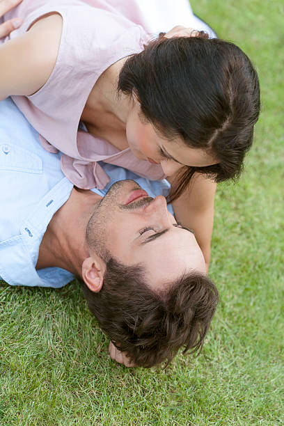 istock romantic young couple lying together in park 497227701