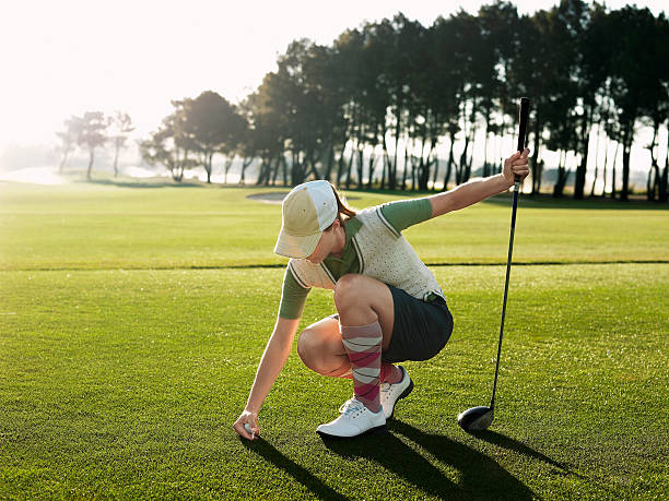 istock Female Golfer Placing Ball On Tee 497230313
