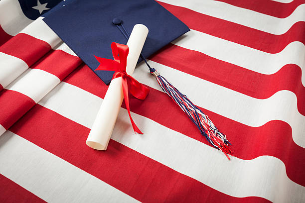 istock Graduation Cap and Diploma Resting on American Flag 497230385