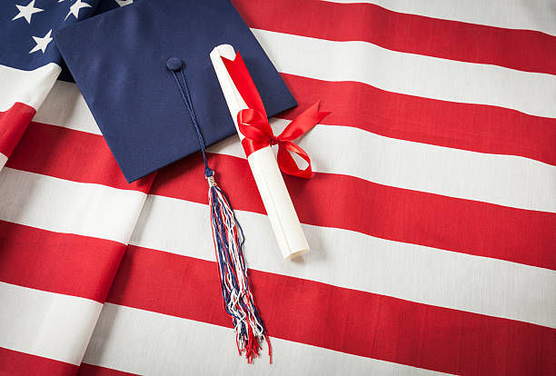 istock Graduation Cap and Diploma Resting on American Flag 497230399