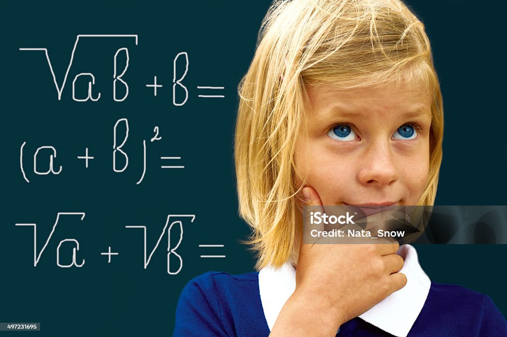 Schoolgirl ponders solving a mathematical problem Schoolgirl ponders solving a mathematical problem standing at the blackboard Adolescence Stock Photo