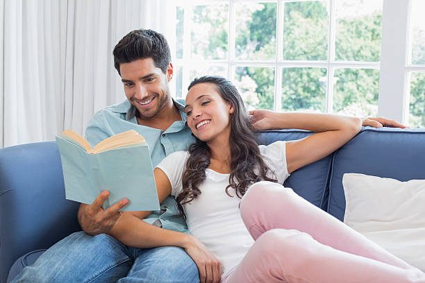 istock Attractive couple relax as they read a book 497233073